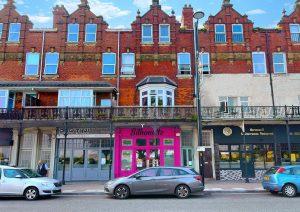 A street scene featuring a row of buildings with distinct architecture. The central building has a bright pink storefront named "Silhouette." To the left is a restaurant with a green sign and to the right is "Moroccan & Mediterranean Restaurant." Several cars are parked along the street at 38 & 38A Alexandra Road, Cleethorpes DN35 8LE.