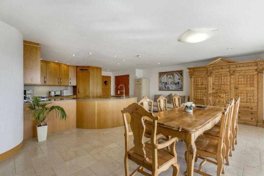 Property for sale by Auction A spacious, well-lit kitchen and dining area with light wood cabinetry and furnishings is a highlight of this Dilks Street home near Bishop DL14 9AP. The modern kitchen features an island with a sink, while the dining area includes a large table with six chairs and a decorative wooden cabinet. Presented by Palace Auctions