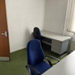 Property for sale by Auction A small office space with two desks is now part of an intriguing investment property available for sale by auction. Each desk has a blue office chair; one is positioned by the door, and the other under a window with closed blinds. The room has white walls and green carpet flooring, adding to its appeal. Presented by Palace Auctions