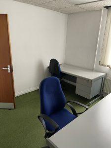 Property for sale by Auction A small office space with two desks is now part of an intriguing investment property available for sale by auction. Each desk has a blue office chair; one is positioned by the door, and the other under a window with closed blinds. The room has white walls and green carpet flooring, adding to its appeal. Presented by Palace Auctions