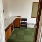 Property for sale by Auction A small, sparsely furnished office with green carpet tiles is available for sale by auction. The room contains a wooden desk with a white top, a wooden cabinet, a black chair, and a white radiator. One wall features a bulletin board. The door to the room is partially open. Perfect investment property on Church Walk! Presented by Palace Auctions