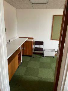 Property for sale by Auction A small, sparsely furnished office with green carpet tiles is available for sale by auction. The room contains a wooden desk with a white top, a wooden cabinet, a black chair, and a white radiator. One wall features a bulletin board. The door to the room is partially open. Perfect investment property on Church Walk! Presented by Palace Auctions