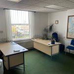 Property for sale by Auction A small office with two desks and blue chairs. One desk is near a window with blinds, the other against the wall with plants on it. Another plant is in the corner. There's a map and a clock on the wall, and a printer is visible in the foreground—an ideal setup for discussing available investment properties for sale by auction. Presented by Palace Auctions
