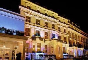 Illuminated exterior of a luxury Victorian-style hotel in Paddington, available for sale by Palace Auctions