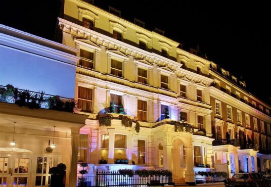 Illuminated exterior of a luxury Victorian-style hotel in Paddington, available for sale by Palace Auctions