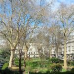 Peaceful urban park surrounded by classic European-style buildings, representing the location of a 3-star hotel for sale near Kensington Gardens