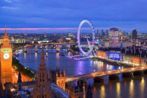 Panoramic view of London at twilight, featuring landmarks such as Big Ben, the Houses of Parliament, and the London Eye