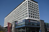Modern multi-story building housing Metroradio under a clear blue sky