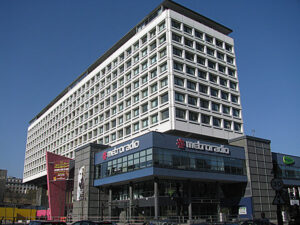 Modern multi-story building housing Metroradio under a clear blue sky