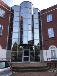 Modern glass-enclosed entrance attached to a traditional brick building on Edgeware Road for sale by auction