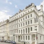 Grand, white-painted multi-story building with classic architectural details, located in Paddington, for sale by Palace Auctions