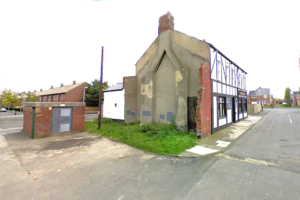 Property for sale by Auction A deteriorating former public house in Jarrow, Tyne and Wear stands at a street corner, with partially missing walls and visible structural damage. The facade shows exposed wooden beams and a significant amount of chipped plaster. Adjacent to it is a small, bricked utility structure. Presented by Palace Auctions