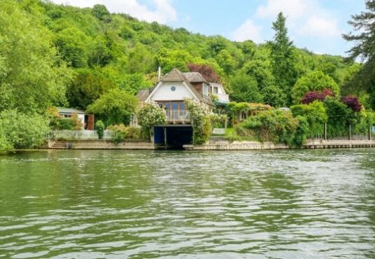 Charming two-story house by the water surrounded by lush greenery in Reading depicting the opportunity to build a similar property