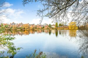 Lakeside scene of a new development with houses and autumnal trees