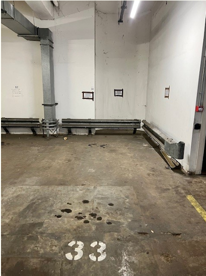 Property for sale by Auction An empty parking space in an indoor parking garage. The ground is concrete with some dark stains and the number "33" is painted in white. The walls are white with some exposed pipes and electrical wiring. Fluorescent lights are visible on the ceiling. Presented by Palace Auctions
