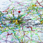 Property for sale by Auction A detailed map of part of England with a red pin marking the city of Manchester. Surrounding cities like Bradford, Huddersfield, and Sheffield are also visible. Various roads, highways, towns, and geographic features are intricately depicted. Presented by Palace Auctions