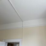 Property for sale by Auction A room with cream-colored walls and a white ceiling. The ceiling has a small light fixture, and there is a white door partially open, leading to another room. The door frame and wall have white trim along the edges. Presented by Palace Auctions