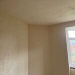 Property for sale by Auction A sparsely decorated room with textured cream walls and a white ceiling. There is a window on the right side, letting in natural light. The walls have slight discoloration and patches, indicating the need for some maintenance or repainting. Presented by Palace Auctions