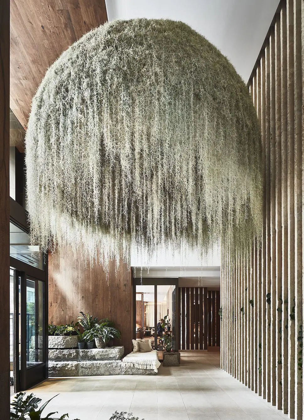 Property for sale by Auction A large, dome-shaped hanging plant installation with cascading greenery dominates a spacious, modern indoor area in Mayfair's new benchmark for luxury apartments. Wooden walls and a glass entrance complement the natural aesthetic, reflecting Central London's record-high values. Presented by Palace Auctions