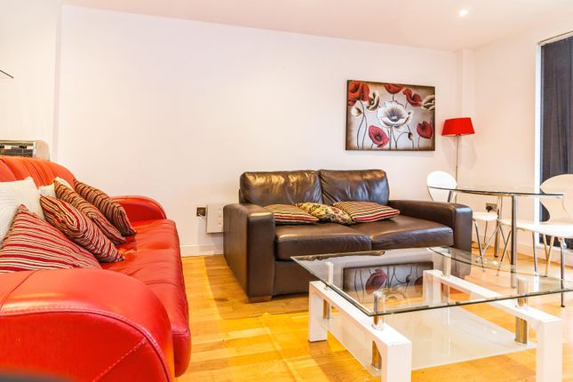 Property for sale by Auction Modern living room with a red sofa, brown loveseat, and a glass coffee table. A floral painting hangs on the wall, and a red floor lamp stands beside a small round table with white chairs. Light wooden flooring completes the space. Presented by Palace Auctions