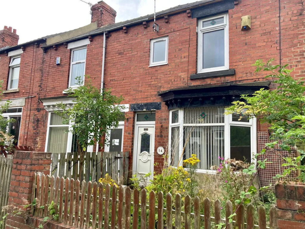 Property for sale A charming Stanley 3-bed terrace on Rose Avenue, this brick family home features a small front garden with overgrown plants, a brown picket fence, white-framed windows, and a white door. Neighboring homes complete this inviting County Durham scene. Presented by Palace Auctions