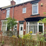 Property for sale A charming Stanley 3-bed terrace on Rose Avenue, this brick family home features a small front garden with overgrown plants, a brown picket fence, white-framed windows, and a white door. Neighboring homes complete this inviting County Durham scene. Presented by Palace Auctions