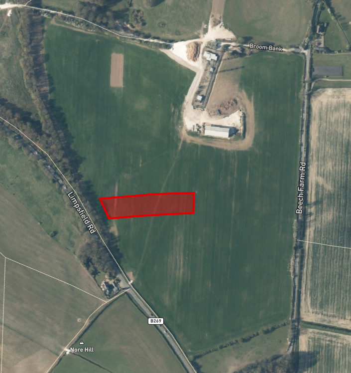 Property for sale Aerial view of green fields intersected by roads, with a freehold land parcel Surrey outlined in red near the center-left, adjacent to Lambfield Road. Buildings and trees are visible at the top and bottom edges. Presented by Palace Auctions