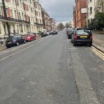 Property for sale A quiet, slightly uphill street lined with parked cars and tall, historic buildings offers a prime location for an investment property—Brighto’s Gwydyr Mansions Brighton apartment for sale—set under a cloudy sky with no people or traffic in sight. Presented by Palace Auctions