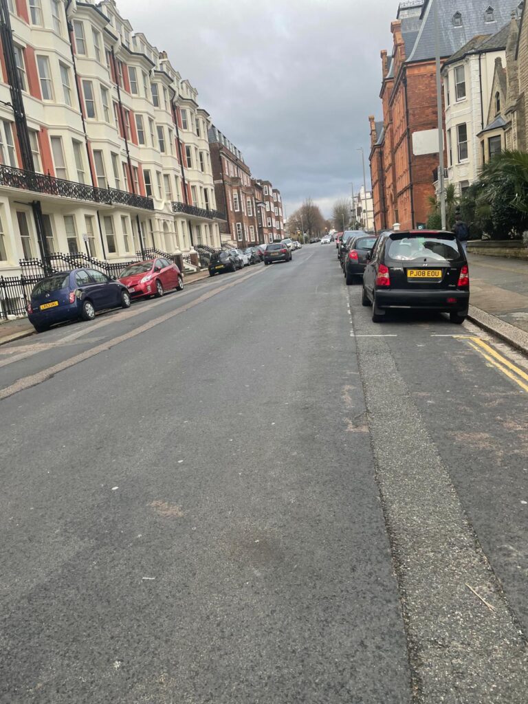 Property for sale A quiet, slightly uphill street lined with parked cars and tall, historic buildings offers a prime location for an investment property—Brighto’s Gwydyr Mansions Brighton apartment for sale—set under a cloudy sky with no people or traffic in sight. Presented by Palace Auctions