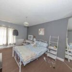 Property for sale A bedroom in this traditional public house conversion Newcastle area features gray walls, blue and white bedding, a large mirror, wall-mounted TV, two nightstands, and sunlight streaming through sheer curtains. Presented by Palace Auctions