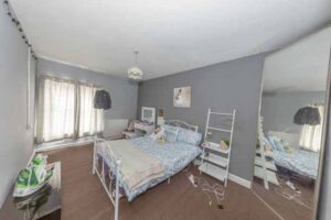 Property for sale A bedroom in this traditional public house conversion Newcastle area features gray walls, blue and white bedding, a large mirror, wall-mounted TV, two nightstands, and sunlight streaming through sheer curtains. Presented by Palace Auctions