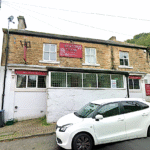Property for sale A two-story stone building with a red sign reading "Burton House" above the entrance, this traditional public house conversion in the Newcastle area features street parking and trees nearby. Presented by Palace Auctions