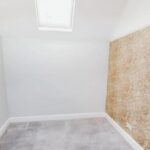Property for sale A small, empty room with white walls, a skylight, light gray carpet, and one wall covered in patterned beige wallpaper—perfect for your next Bowdon investment property. Presented by Palace Auctions