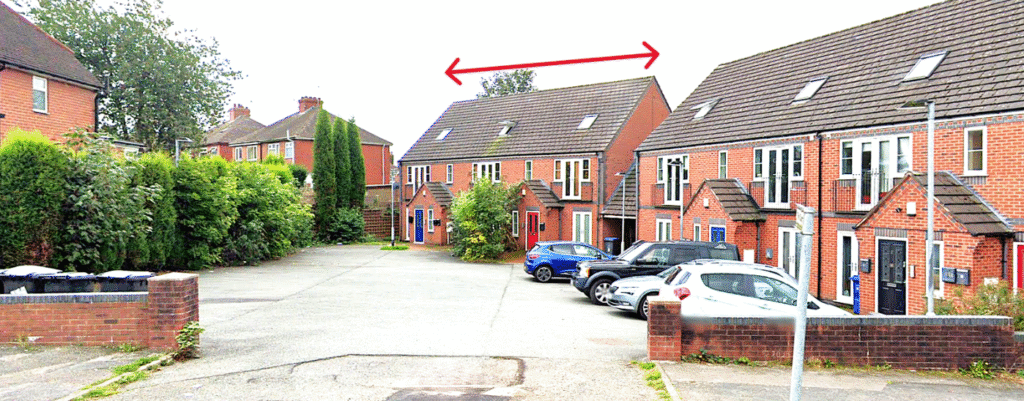 Property for sale A residential street with brick houses and parked cars. A red double-headed arrow above the roof of a house indicates the width of this Newcastle-under-Lyme auction property. Presented by Palace Auctions