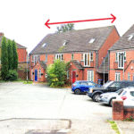 Property for sale A residential street with brick houses and parked cars. A red double-headed arrow above the roof of a house indicates the width of this Newcastle-under-Lyme auction property. Presented by Palace Auctions
