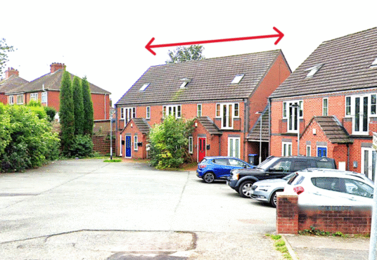 Property for sale A residential street with brick houses and parked cars. A red double-headed arrow above the roof of a house indicates the width of this Newcastle-under-Lyme auction property. Presented by Palace Auctions