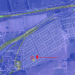 Property for sale A satellite map with outlined plots; a bold red arrow points to a specific rectangular plot near the center, highlighted with a red circle. Main roads border this land auction site in Guildford, surrounded by fields and buildings. Presented by Palace Auctions