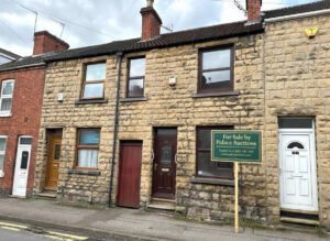 Property for sale A stone-fronted 2-bed Mansfield house with a dark brown door and window, nestled between two homes at 35 Padley Hill Mansfield, is offered as an auction property NG18 5LJ. A "For Sale by Palace Auctions" sign is displayed on the pavement. Presented by Palace Auctions