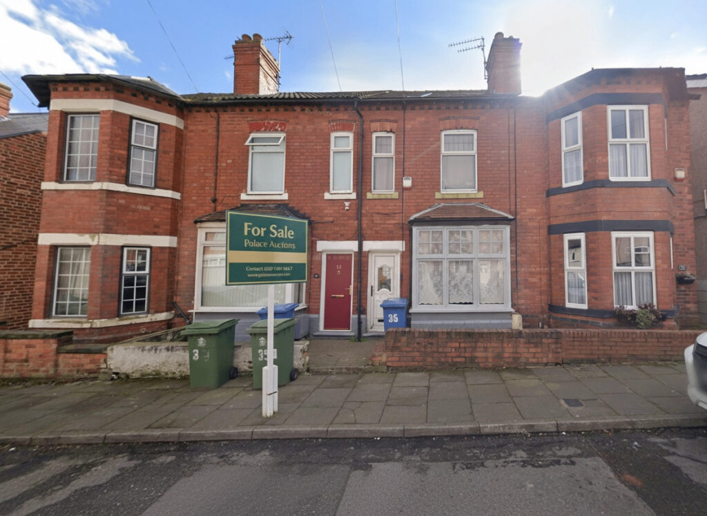 Property for sale A red brick terraced house with white trim and a bay window features a "For Sale PAKeet Auctions" sign, ideal for those seeking auction properties in Mansfield. Green bins and a blue door number 35 are visible by the entrance. Presented by Palace Auctions