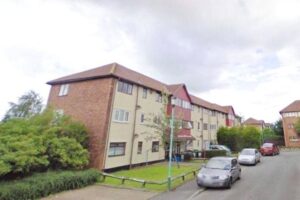 Property for sale A three-story apartment building with beige walls and brown roofing, ideal for buy-to-let Hartlepool investors. Surrounded by a small lawn and bushes, several parked cars line the street in front of the building under a cloudy sky. Presented by Palace Auctions