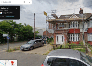 Property for sale A semi-detached house, ideal for HMO investment Hayes, with scaffolding on the upper floor, a red front door, overgrown grass, and two cars parked in the driveway on a cloudy day at the corner of Chalfont Road, England. Presented by Palace Auctions