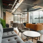 Property for sale A modern lounge at Langford Tower Sheffield features gray and tan sofas, armchairs, round tables, large windows, indoor plants, and industrial-style exposed ceilings—perfect for those seeking modern flats in Sheffield filled with natural light. Presented by Palace Auctions