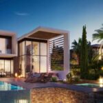 Property for sale Modern two-story house with large windows, a swimming pool, lounge chairs, and lush green trees—an elegant example of Pegeia luxury real estate, beautifully illuminated by outdoor lighting at dusk. Presented by Palace Auctions