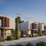 Property for sale Modern two-story houses, like Morea Coral Bay villas, with large windows and wooden shutters line a tree-lined street at sunset; people walk, a child bikes, and cars are parked in driveways surrounded by greenery. Presented by Palace Auctions