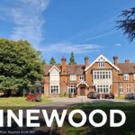 Property for sale A large, historic brick building with white-framed windows and a gabled roof, surrounded by trees and parked cars, under a clear blue sky. Text reads: "PINEWOOD, 93 College Ride, Bagshot GU19 5EP. Presented by Palace Auctions