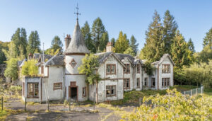 Property for sale An abandoned, two-story Victorian-style house with peeling white paint, a turret, broken windows, and overgrown vegetation—this Scottish manor house for sale is surrounded by tall trees under a clear blue sky. Presented by Palace Auctions