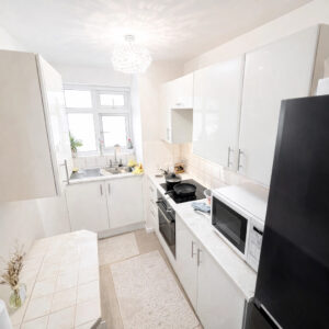 Property for sale A bright, modern kitchen with white cabinets, a black fridge, and an electric stove—ideal for a buy-to-let West Bridgford investment. The room features tiled floors, a window above the sink, and stylish decorative touches throughout. Presented by Palace Auctions