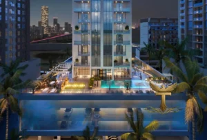 Property for sale Modern high-rise building with a lit outdoor pool and lounge at dusk, surrounded by palm trees and city skyline, featuring the gold "Transparency Real Estate" logo—showcasing Ra1n Residence JVC flat, a premier Dubai smart home property. Presented by Palace Auctions