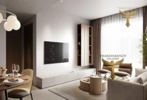 Property for sale Modern living room in a luxury flat with a wall-mounted TV, sleek white cabinet, and round coffee table. Light beige sofas face a large window with sheer curtains. Dining area is partially visible—located in Dubai’s Jumeirah Village Triangle. Presented by Palace Auctions