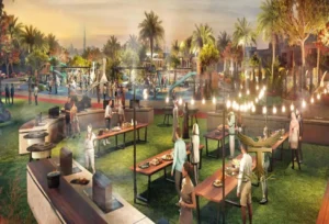 Property for sale People gather outdoors in a park-like setting at DAMAC Riverside, enjoying food from buffet tables. With green grass, barbecues, string lights, palm trees, and a playground nearby, it creates a lively, festive atmosphere perfect for residents. Presented by Palace Auctions